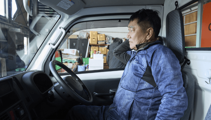 キャリイの車内でシートベルトをする男性