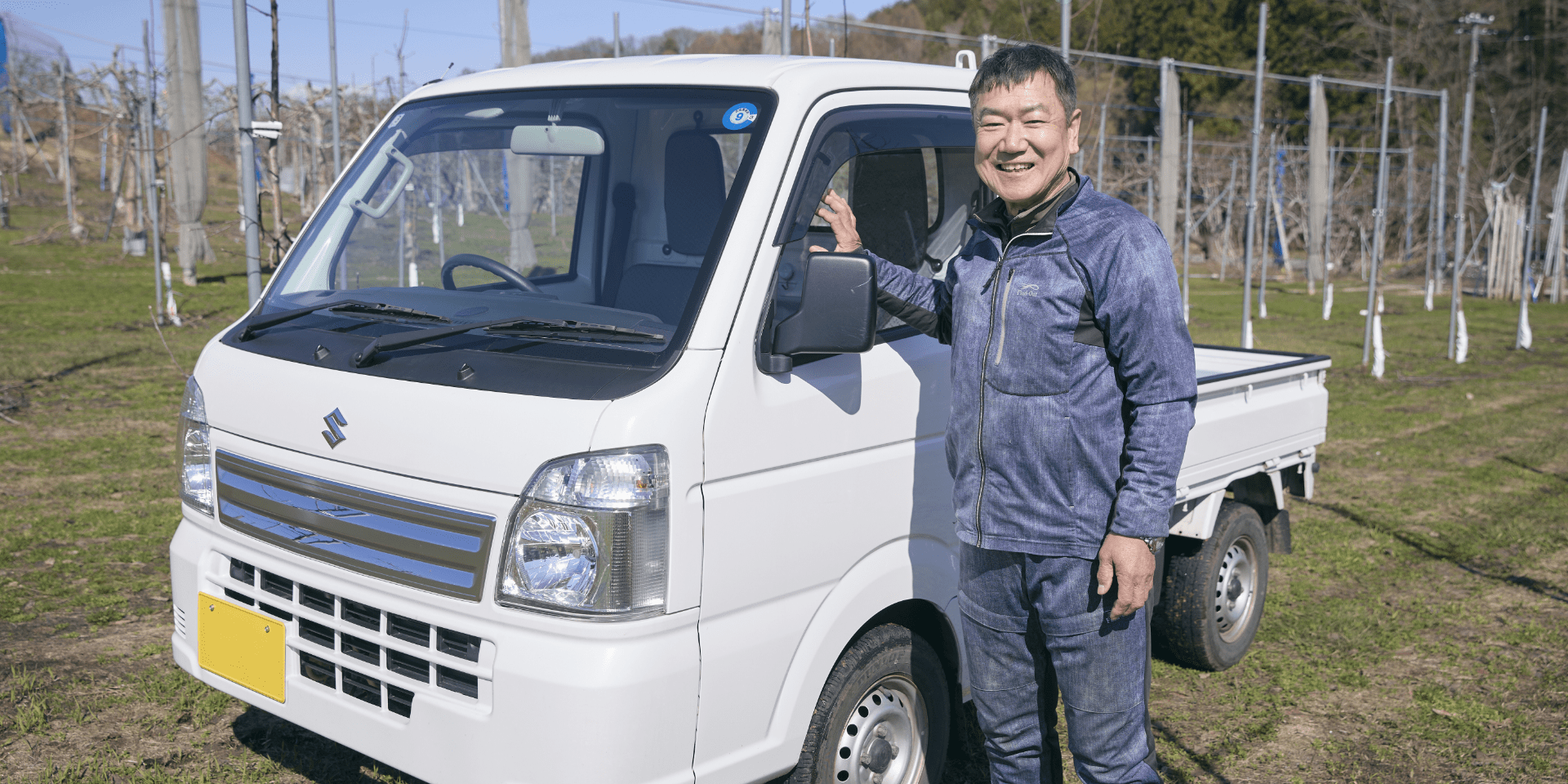 村上さんと相棒キャリイ。これからもおいしいりんごを届けつづける。