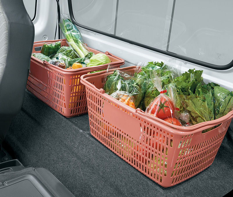 スーパーキャリイのシートバックスペースに、野菜が入った買い物かごが置かれている様子。マイバスケットなどの買い物かごがすっぽり収まります。